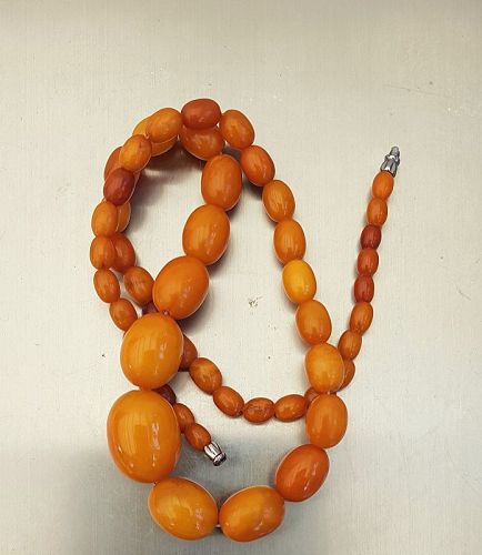 A long graduated single-strand butterscotch amber bead necklace, beads  ranging from 28.1mm to 9.8mm,